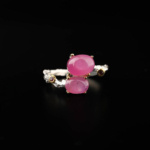 Anillo de diseño de lujo para mujer en plata de ley 925 con garras de oro, adornado con dos rubíes naturales de corte cabujón.