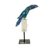 Figura elegante de loro esculpida en sodalita, calcita azul y cristal de roca sobre soporte de metal.