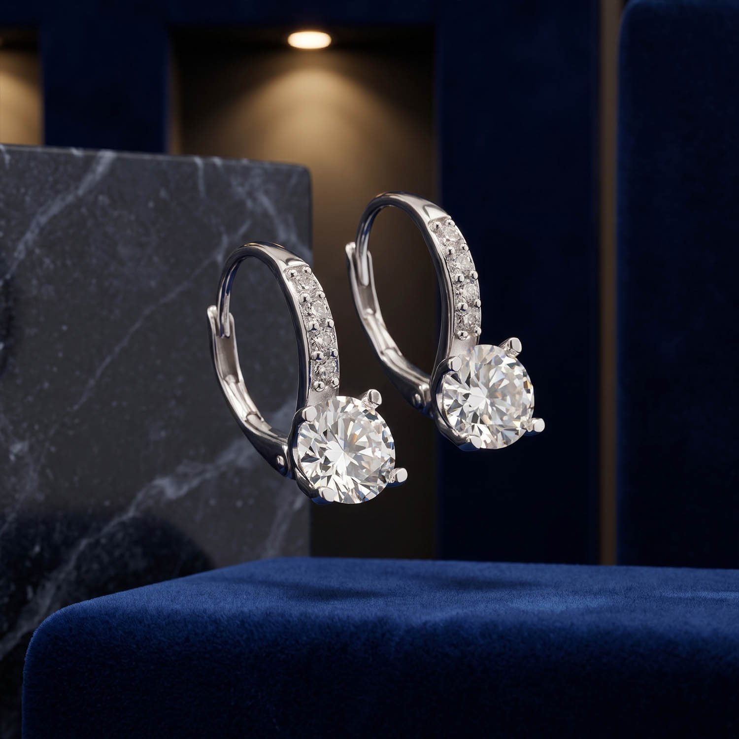 orijinal-sertifikali-moissanite-mozanite-925-ayar-gumus-tasarim-kupe Ön kolları sıralı mikro taşlı halka montürde dört tırnaklı yuvarlak kesim orijinal mozanit taşlı ve GRA sertifikalı 925 ayar gümüş tasarım lüks küpe modeli.
