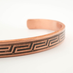 Pulsera fina de diseño en cobre puro con motivo de greca antigua exterior en banda oxidada.