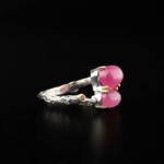 A luxury women's statement ring featuring original oval cabochon rubies with gold prongs set in a 925 sterling silver twig design.