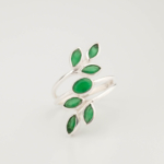 A luxury women's statement ring featuring original oval and marquise faceted emerald gemstones arranged in an ivy leaf design on a 925 sterling silver bypass band.