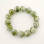 A luxury statement gemstone bracelet featuring original 16-17mm 5A+ grade green serpentine round beads on a stretch band.