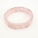 A luxury statement gemstone bracelet featuring original super seven rolex-cut beads on a stretch band.