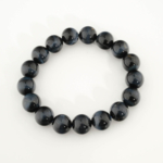 A stylish statement bracelet featuring original 12-13mm 6A+ grade blue tiger's eye round beads with intense chatoyancy.