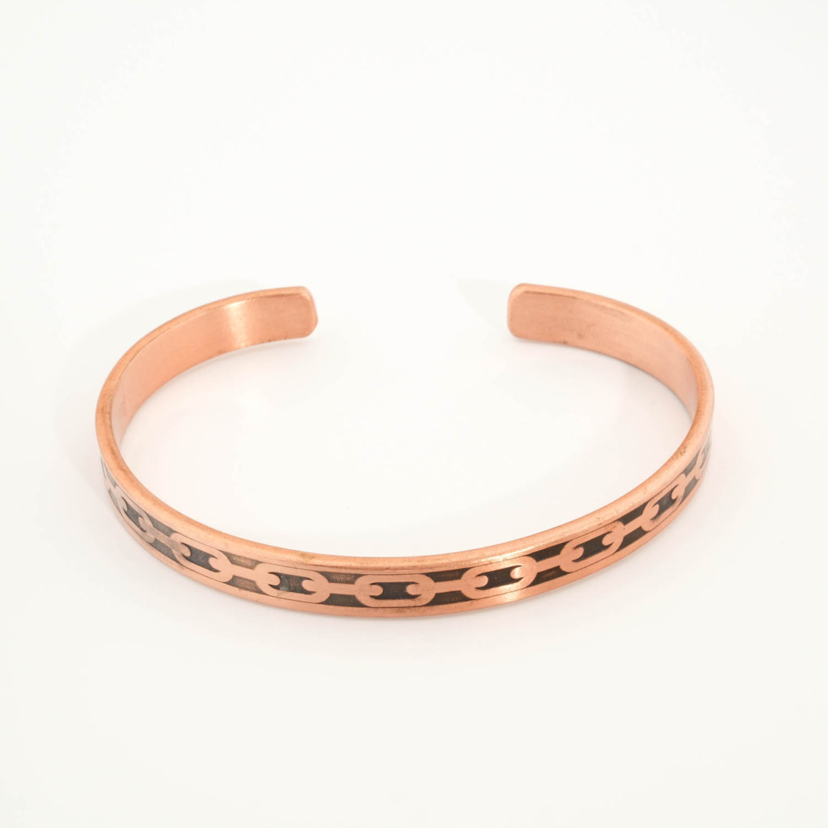 A handcrafted thin pure copper cuff bracelet featuring an engraved geometric chain link pattern with black oxidation.