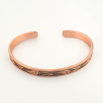 A handcrafted thin pure copper cuff bracelet featuring an engraved traditional tulip pattern with black oxidation.