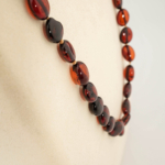 A certified original Baltic amber gemstone adult necklace (15-18g, 54-58cm) featuring smooth dark cognac amber beads.