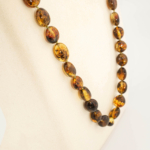 Collana da adulto in ambra baltica naturale originale certificata da 23-28g con grani color cognac scuro.