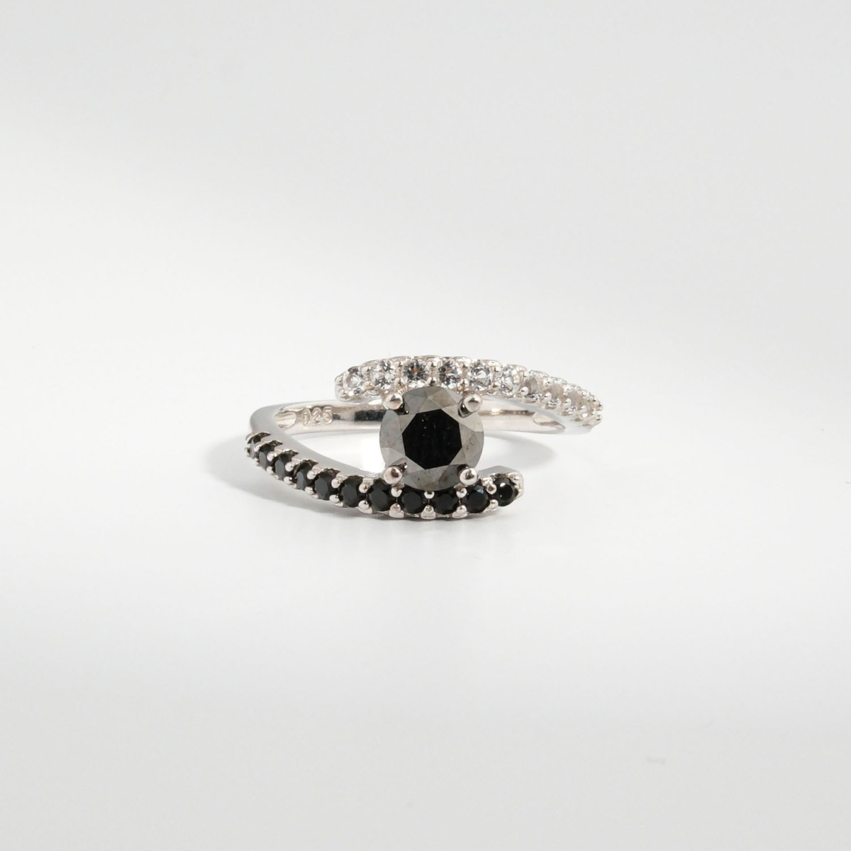 A 925 sterling silver women's bypass ring featuring a natural round faceted black diamond gemstone with black and white cubic zirconia bands.