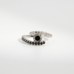 A 925 sterling silver women's bypass ring featuring a natural round faceted black diamond gemstone with black and white cubic zirconia bands.