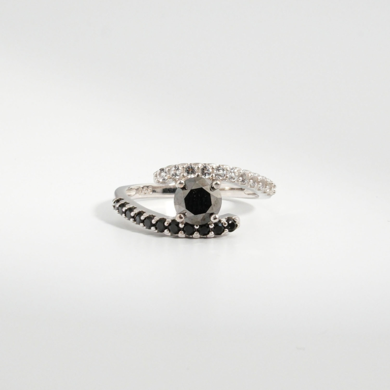 A 925 sterling silver women's bypass ring featuring a natural round faceted black diamond gemstone with black and white cubic zirconia bands.
