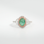 A 925 sterling silver women's ring featuring a 1.24 ct natural oval green Zambian emerald gemstone with pink and white cubic zirconia halo.