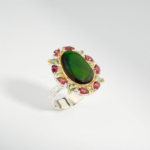 A 925 sterling silver women's ring featuring a natural oval green ammonite opal gemstone surrounded by garnet and peridot stones.