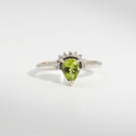 A 925 sterling silver women's ring featuring a 1 ct natural pear-shaped green peridot gemstone with a 0.10 ct diamond tiara halo.