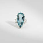 A 925 sterling silver women's ring featuring an 18 ct natural pear-shaped faceted blue topaz gemstone in a high prong setting.