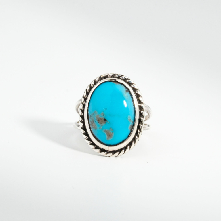 A 925 sterling silver women's ring featuring a natural oval cabochon turquoise gemstone with twisted rope silver bezel.