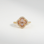 A 925 sterling silver gold-plated women's ring featuring a color-changing clover-shaped zultanite gemstone surrounded by cubic zirconia.