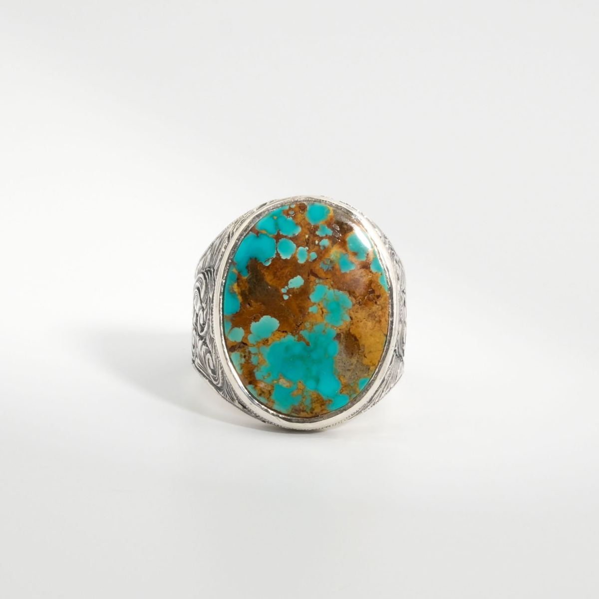 A 925 sterling silver handmade men's ring featuring a natural oval cabochon cut turquoise gemstone with brown matrix patterns.