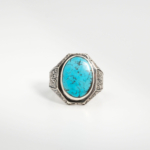 A 925 sterling silver handmade men's ring featuring a natural oval cabochon cut Nishapur turquoise gemstone with fine black spiderweb matrix.