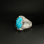 A 925 sterling silver handmade men's ring featuring a natural oval cabochon cut Nishapur turquoise gemstone with claw bezel settings.