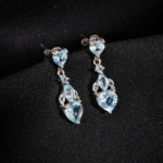 A pair of original heart cut blue topaz natural stone 925 sterling silver dangle drop earrings with zircon accents.
