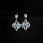 Çiçek motifli mekik ve damla kesim orijinal blue topaz doğal taşlı 925 ayar gümüş sallantılı zirkonlu kadın küpe modeli.