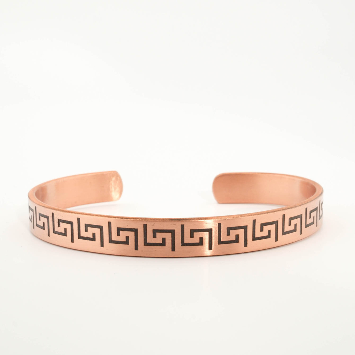 A pure copper handmade open cuff bracelet featuring Greek key meander patterns on top and Ayat al-Kursi inside.