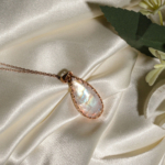 Colgante de plata 925 chapada en oro rosa con piedra luna natural en forma de gota sobre seda blanca.
