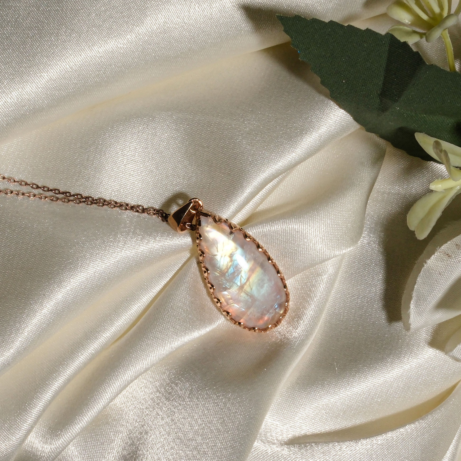 colgante-mujer-piedra-luna-natural-gota-plata-925-oro-rosa.jpg Colgante de plata 925 chapada en oro rosa con piedra luna natural en forma de gota sobre seda blanca.