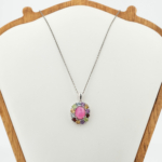 Pendentif pour femme en argent 925 avec rubis rose central et pierres naturelles multicolores étincelantes sur tissu blanc.