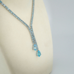 A 925 sterling silver 43cm women's tennis necklace featuring natural round and drop-shaped blue topaz gemstones.