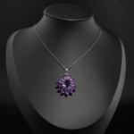 Natural purple amethyst gemstone flower cluster pendant necklace in 925 sterling silver on white silk.