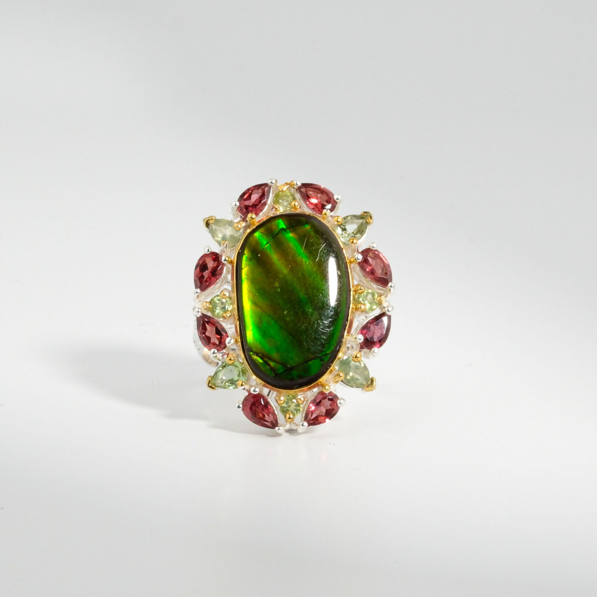 Bague pour femme en argent 925 sertie d'une opale ammonite naturelle entourée de grenats et péridots.