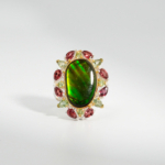 Bague pour femme en argent 925 sertie d'une opale ammonite naturelle entourée de grenats et péridots.