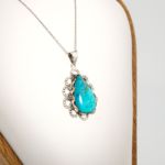 A 925 sterling silver handmade teardrop pendant featuring a natural blue-green chrysocolla gemstone.