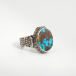 A 925 sterling silver handmade men's ring featuring a natural oval cabochon cut Nishapur turquoise gemstone with brown matrix patterns.