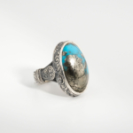 Bague pour homme faite main en argent 925 sertie d'une turquoise naturelle de Nishapur taillée en cabochon avec veine pyrite metalique.