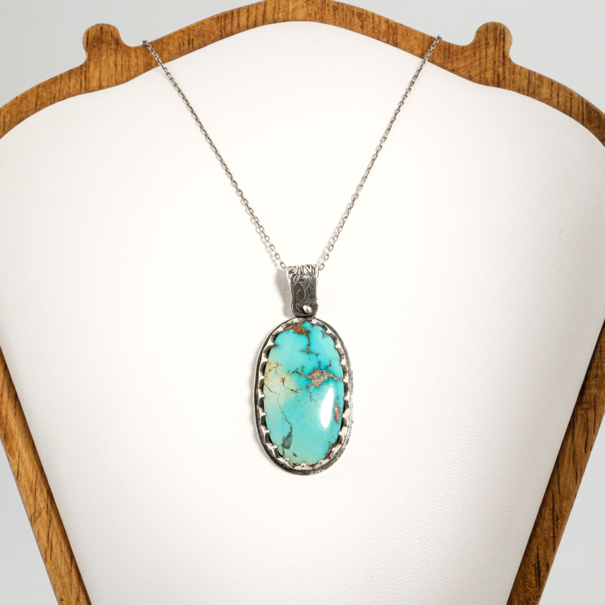A 925 sterling silver handmade unisex pendant featuring a natural oval Nishapur turquoise gemstone.