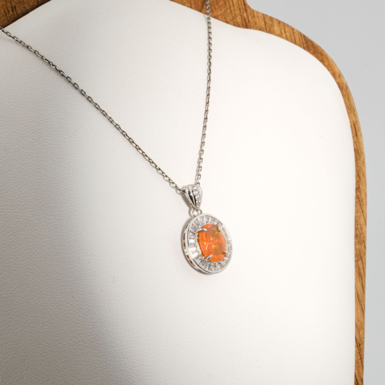 A 925 sterling silver women's pendant featuring an oval natural orange fire opal gemstone surrounded by baguette cubic zirconia halo.