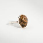 A 925 sterling silver women's ring featuring a natural oval cabochon pietersite gemstone with golden brown chatoyancy.