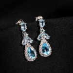A pair of original blue topaz natural stone 925 sterling silver drop dangle earrings with zircon halo accents.