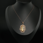 Rose gold plated 925 sterling silver women necklace featuring an oval cabochon natural gold rutilated quartz in floral frame.