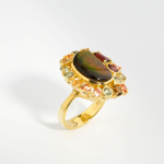 Bague pour femme en argent 925 doré sertie d'une opale ammonite naturelle entourée de citrines, grenats, saphirs jaunes et améthystes vertes.