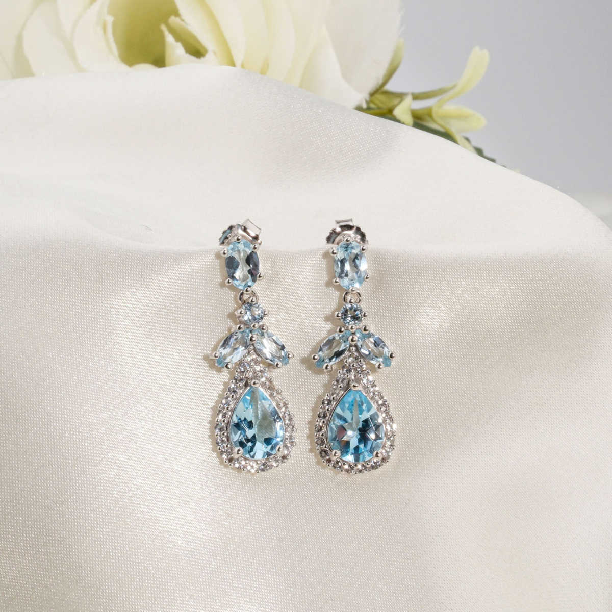 Damla kesim orijinal blue topaz doğal taş zirkon detaylı 925 ayar gümüş sallantılı kadın küpe modeli.