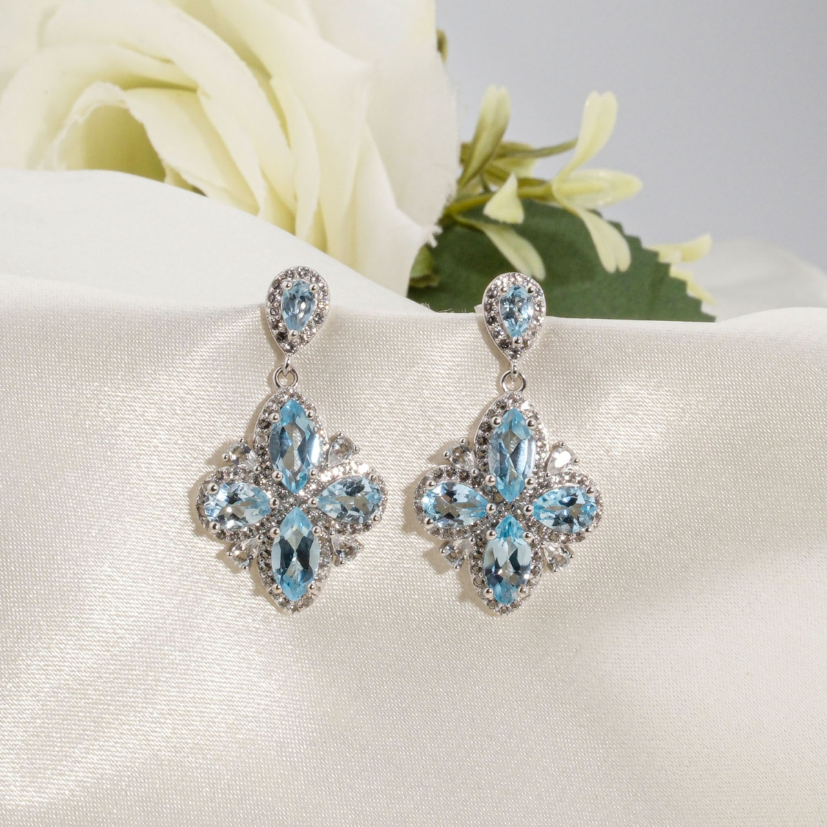 Boucles d'oreilles pendantes en argent 925 avec topaze bleue naturelle originale en motif fleur et zircons.