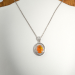 Pendentif pour femme en argent 925 serti d'une opale de feu orange naturelle entourée de zircons baguette.