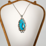 A 925 sterling silver handmade unisex pendant featuring a natural long oval cabochon cut Nishapur turquoise gemstone with pyrite matrix.