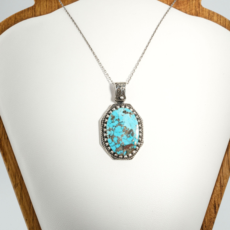 A 925 sterling silver handmade unisex pendant featuring a natural oval Nishapur turquoise gemstone with pyrite spots.