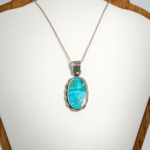 A 925 sterling silver handmade unisex pendant featuring a natural oval Nishapur turquoise gemstone.
